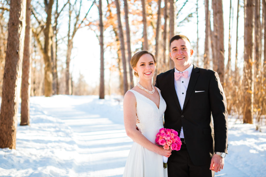 A couple smiles as they pose for a portrait during their winter elopement