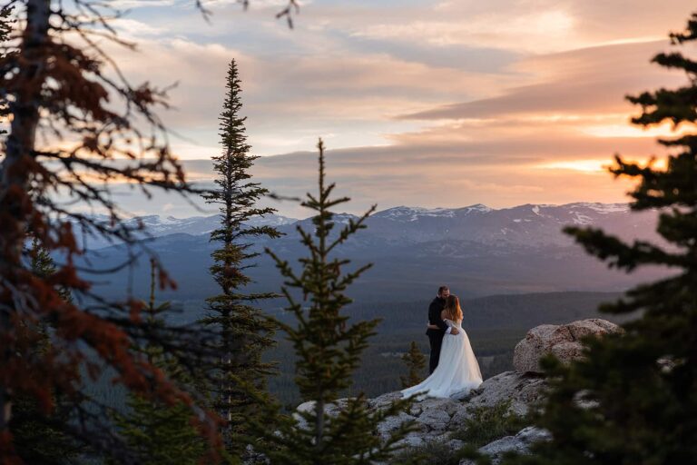 A couple watch the sunrise over the mountains during their Bighorn elopement.
