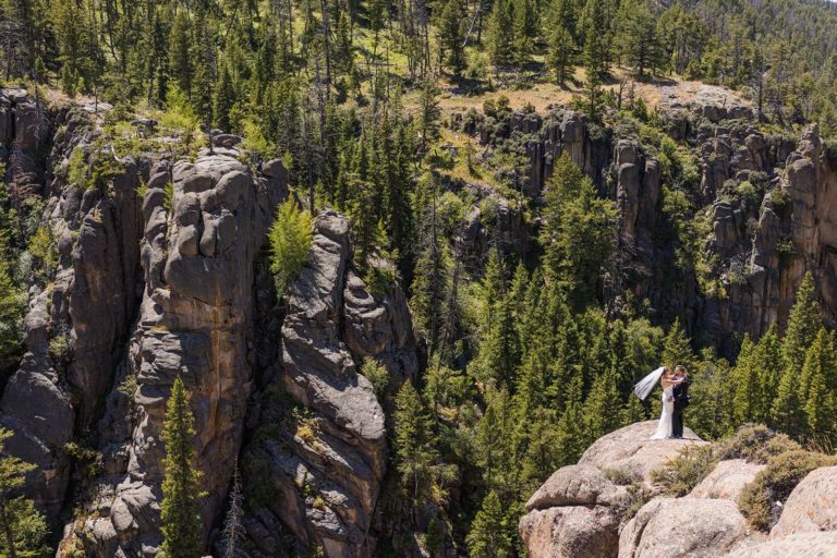 A bride and groom stand on a rocky outcropping in Shell Canyon during their elopement in the Bighorn National Forest in Wyoming.