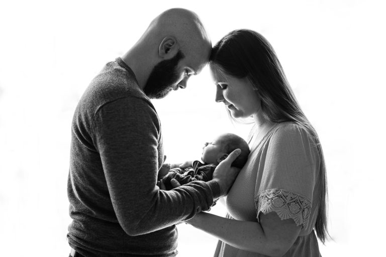 A couple cradles their newborn baby