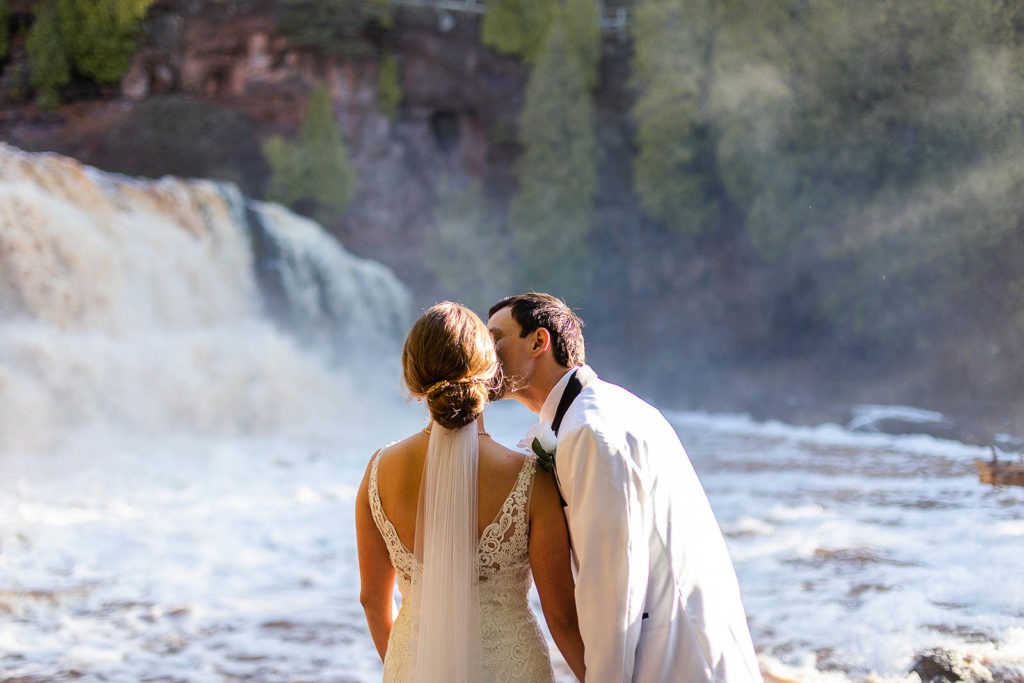 North Shore of Lake Superior Elopement Intimate Wedding A couple take in the breathtaking sight of Gooseberry Falls on their wedding day.