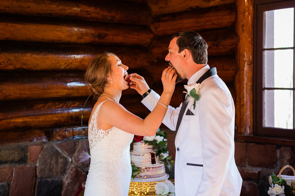 A newly married couple feeds each other cake in the Lakeview Shelter at Gooseberry Falls State Park