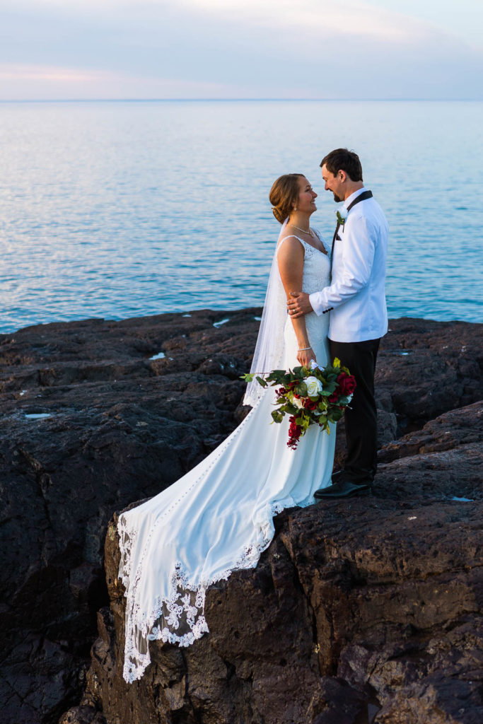 A couple embraces on the north shore of Lake Superior during their Gooseberry Falls State Park Intimate wedding.