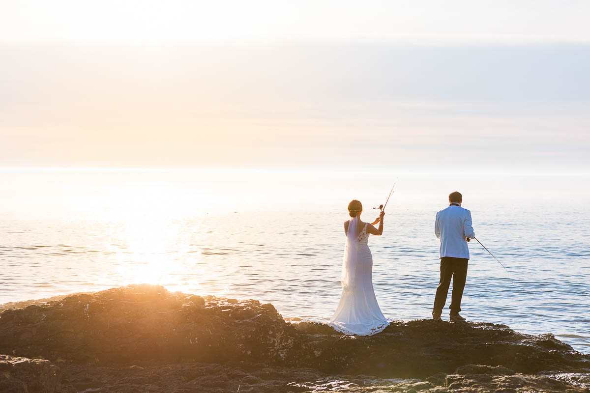 A bride and groom fish on the edge of Lake Superior during their Gooseberry elopement.