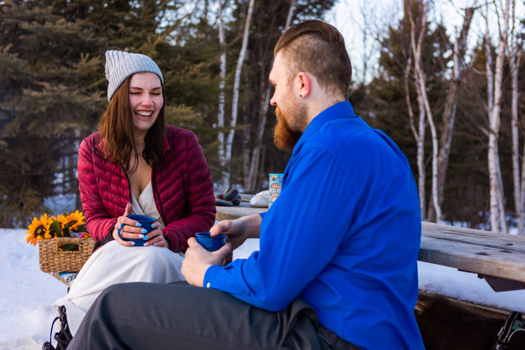 A couple drinks hot chocolate together during their winter elopement at Split Rock Lighthouse State Park.