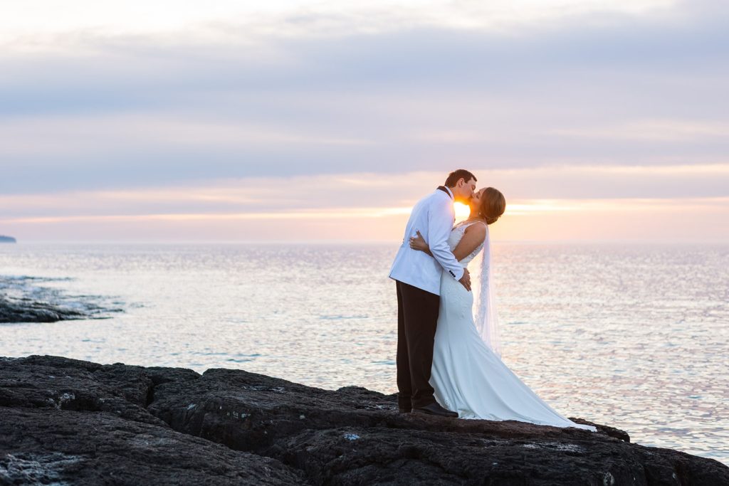 A couple kiss during sunrise on their wedding day during their Gooseberry elopement.