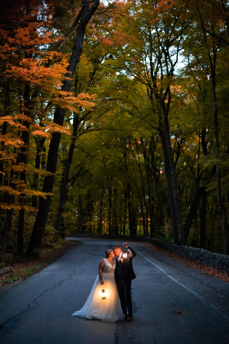 Lit by the light of their lanterns, a bride and groom kiss during their fall Devil's Lake elopement. Fall is one of the best times of year to elope!