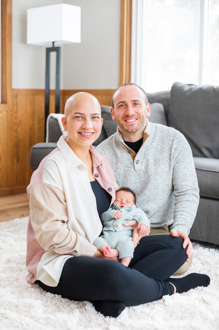 A new mother and father smile with their newborn baby in their living room in Minneapolis, MN.