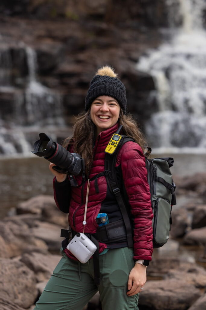 Forever and Evergreens photographer, Tali, smiles while holding her camera during a Minnesota North Shore elopement.