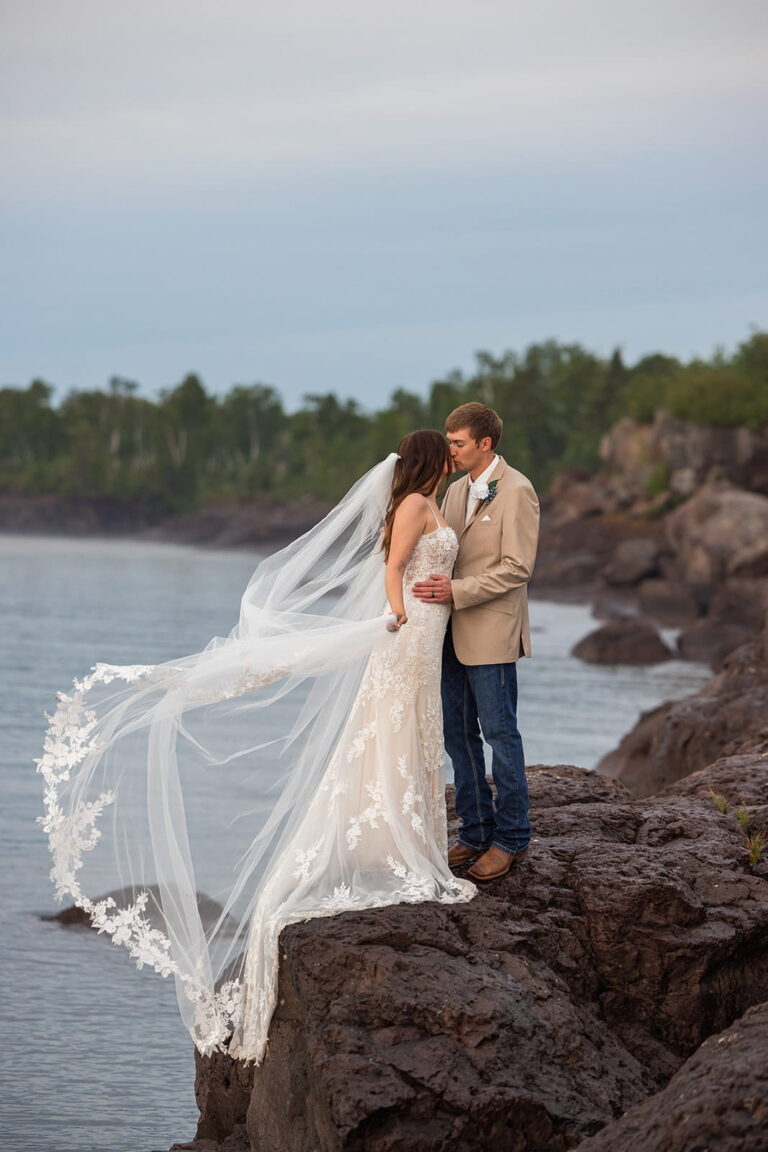 A bride's wedding veil is swept up in the wind during her Minnesota North Shore elopement along Lake Superior.