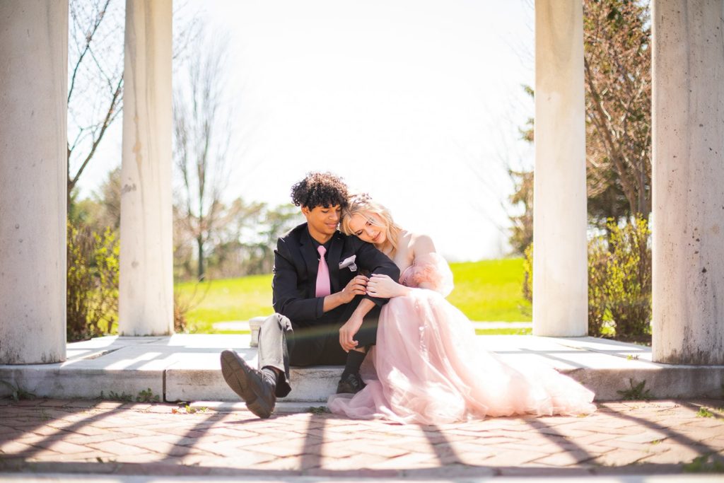 A couple sits under a beautiful pergola in Como Park and Conservatory during their photoshoot in St. Paul, MN.