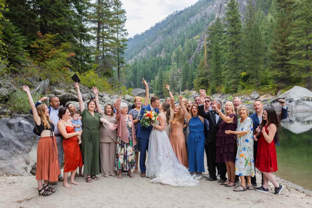 A group of people cheer around a newly married couple during a mountain adventure wedding in Washington state.