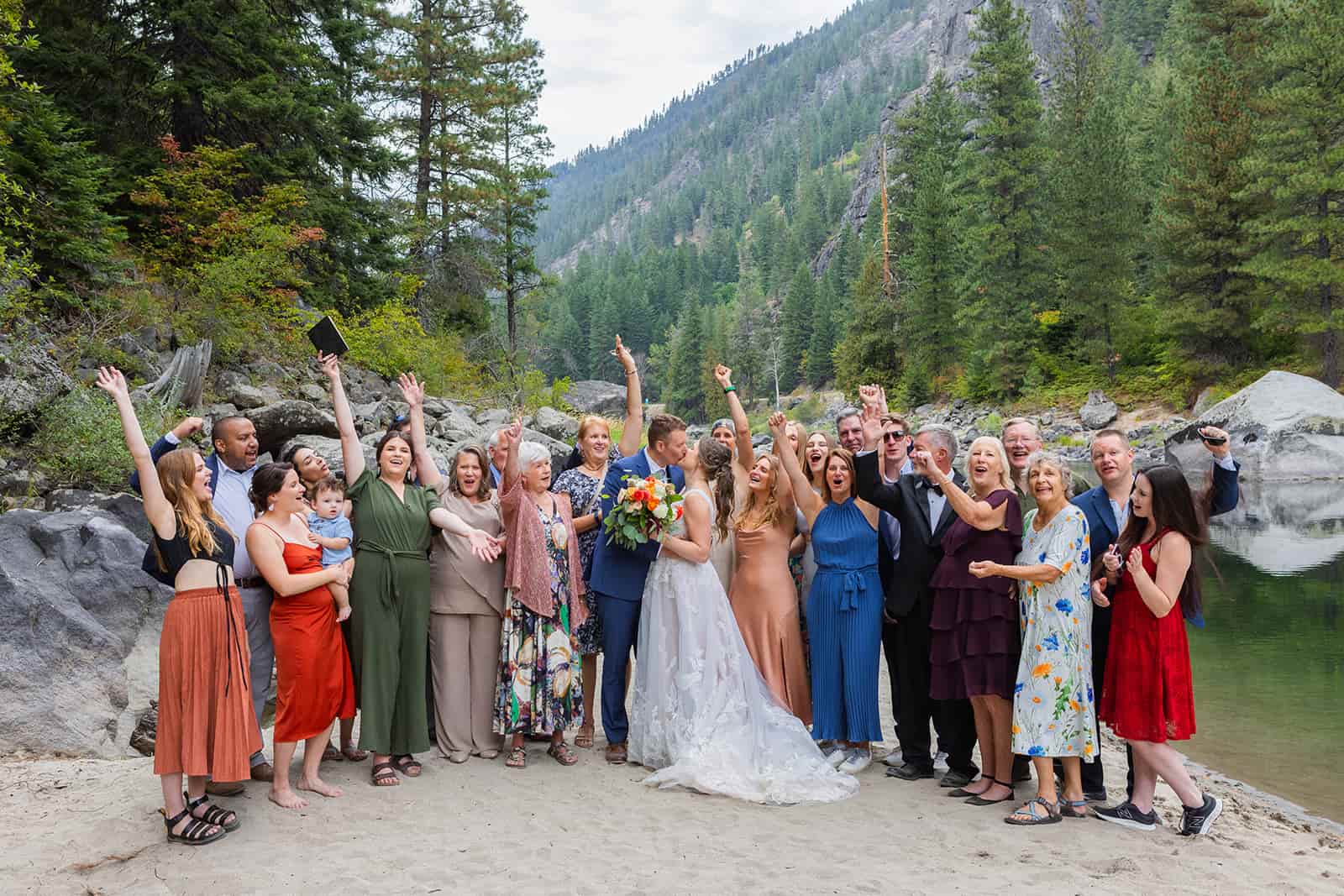 A group of people cheer around a newly married couple during a mountain adventure wedding in Washington state.