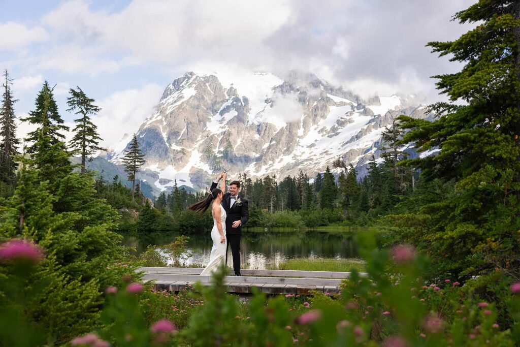 A couple dance on the boardwalk in front of Picture Lake near the Mount Baker ski area during their elopement.