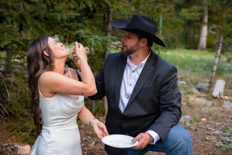A bride and groom eat their wedding cake in the middle of the forest during their adventure elopement with Forever and Evergreens Photography.