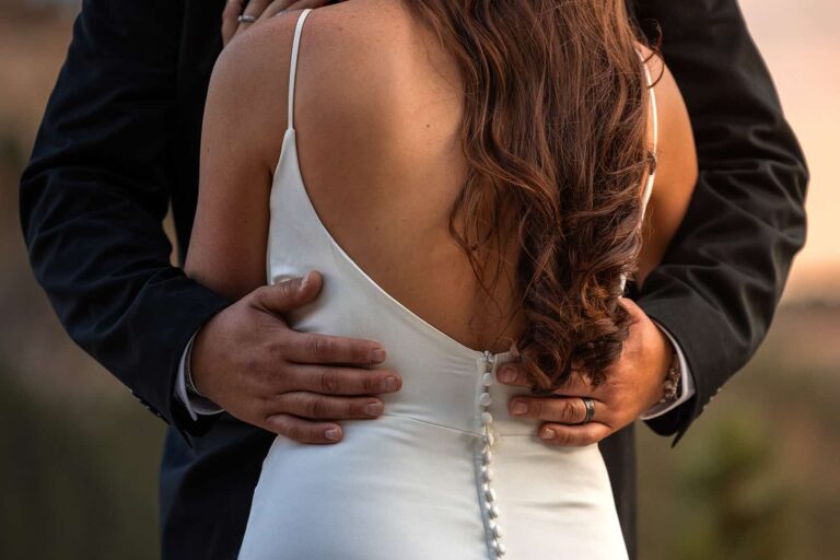A close up image of a bride and groom embracing during sunset on their elopement day.