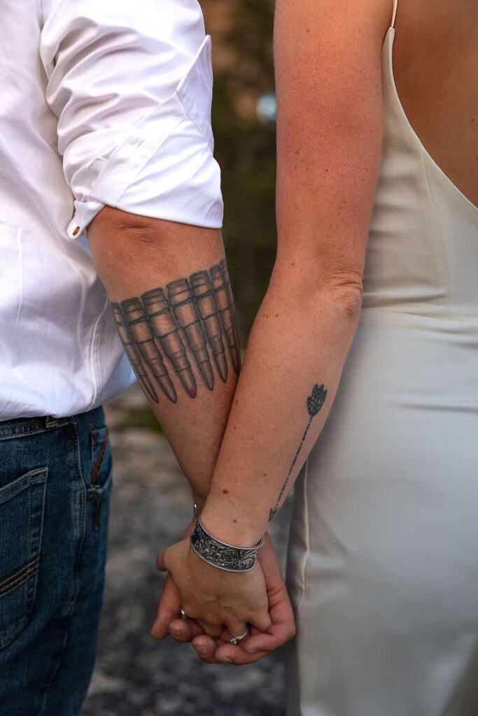 A close up image of a man and woman holding hands.