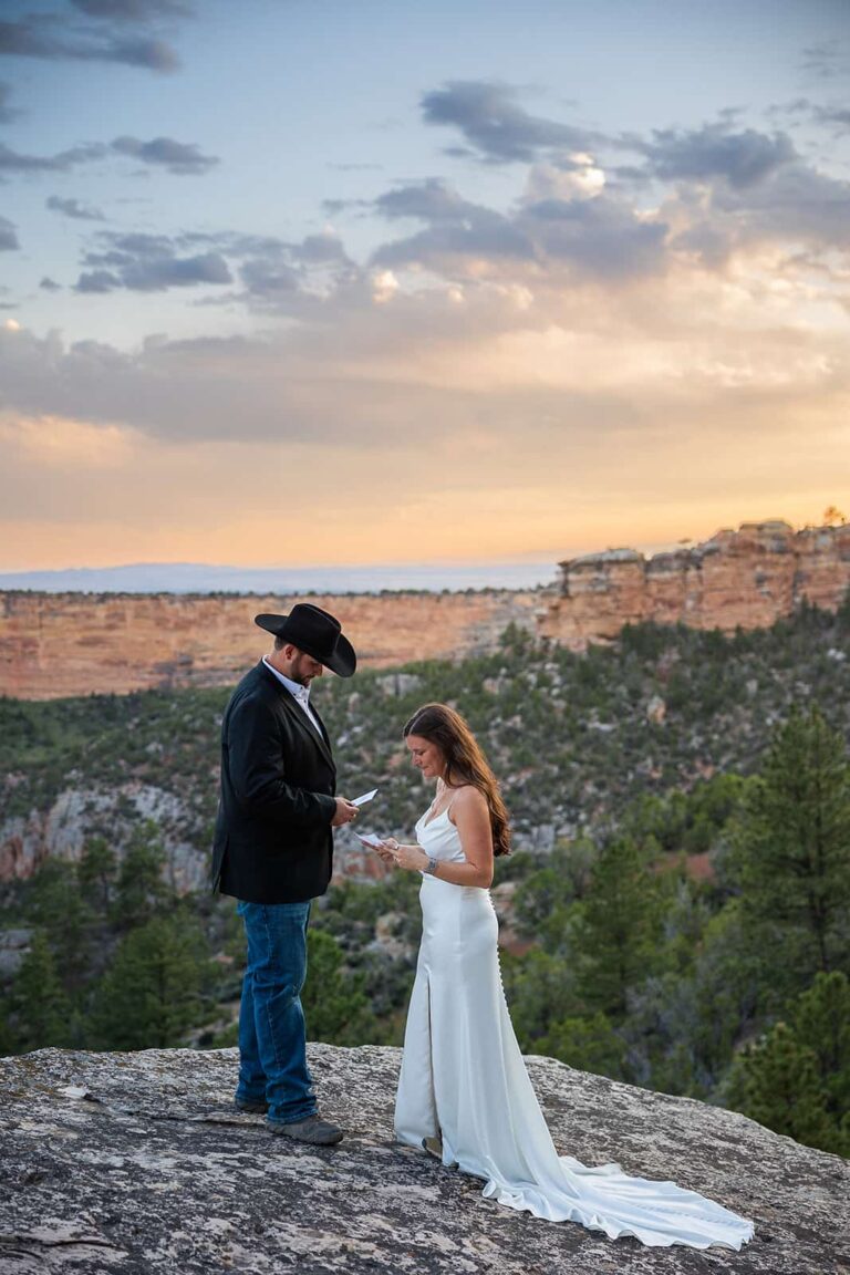 A couple reads private letters on a rocky overlook during sunset after their Meadowlark Lake Wedding in Wyoming.