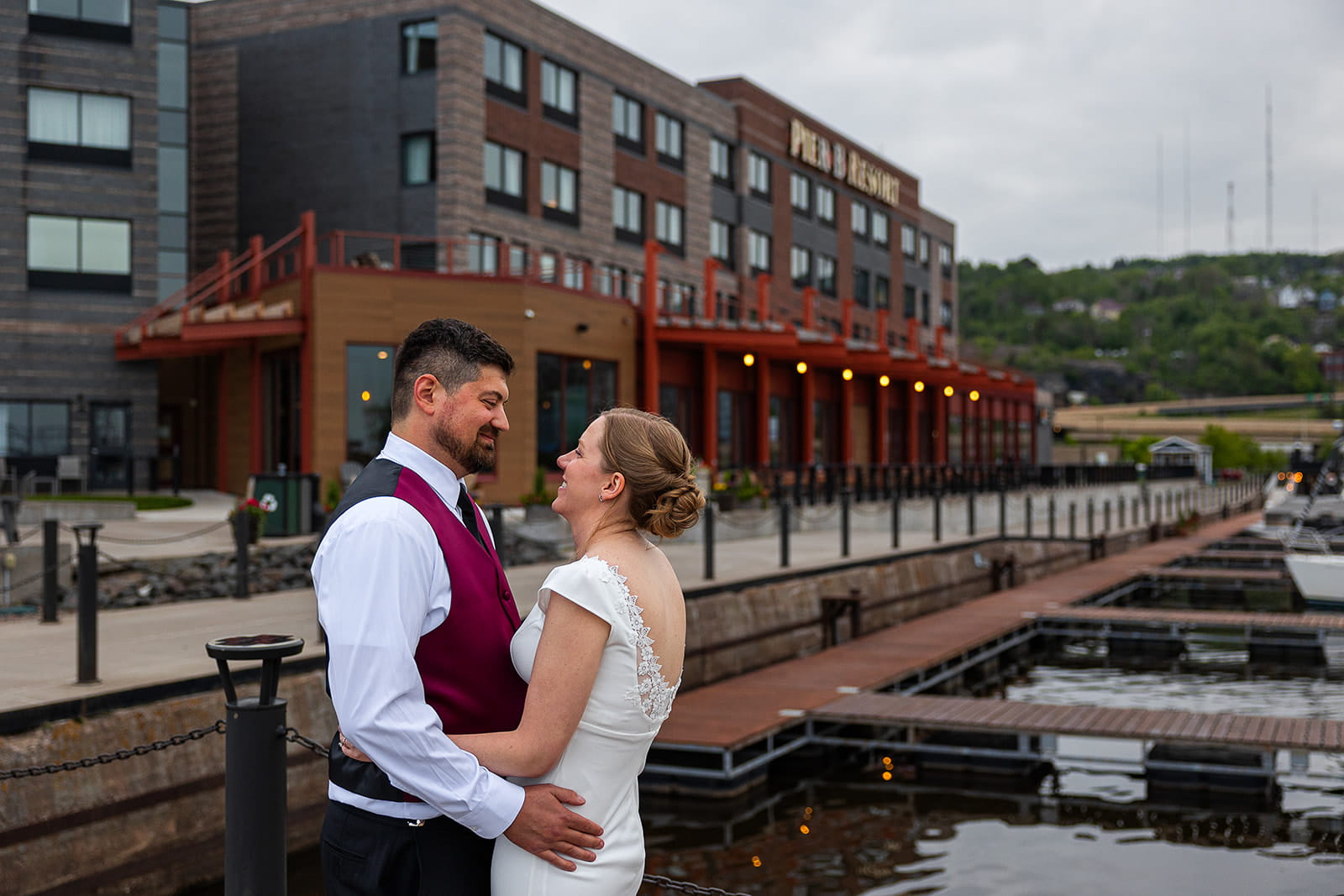 A couple embrace in front of the Pier B wedding venue.