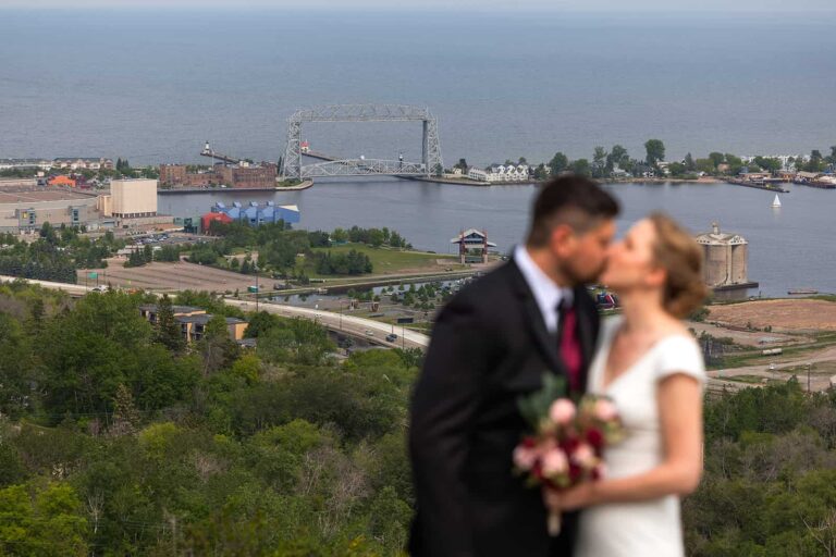 During their Pier B wedding, a couple pose for a picture on a hill high above their wedding venue.