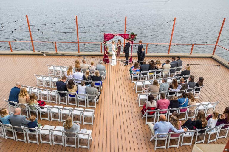 A bird's eye view photo of a wedding ceremony taking place on The Deck at Pier B Resort Hotel in Duluth, MN.