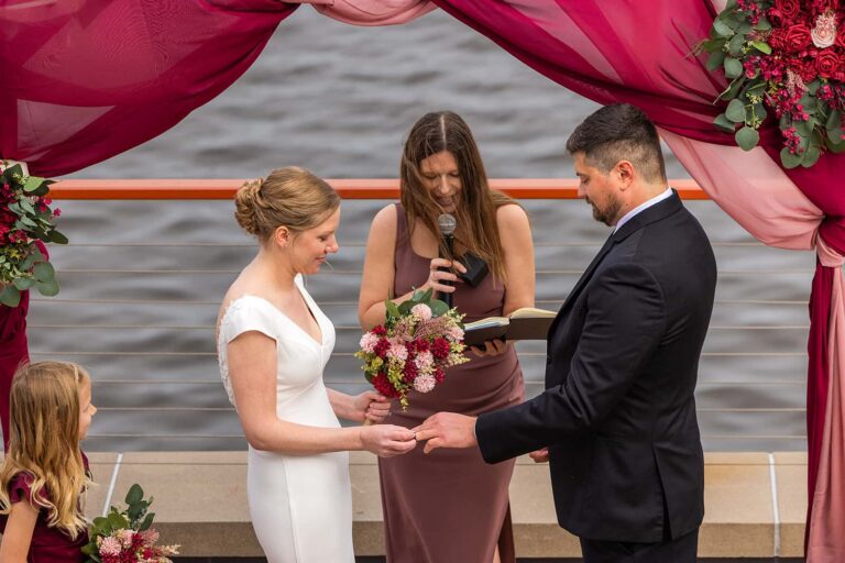 A couple exchanges rings during their wedding ceremony at Pier B Resort.