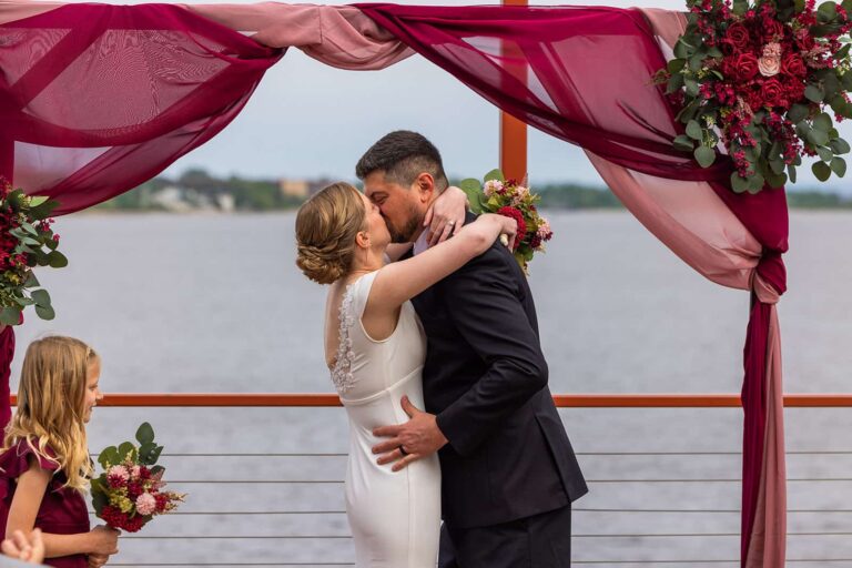 A bride and groom share their first kiss on The Deck at Pier B.