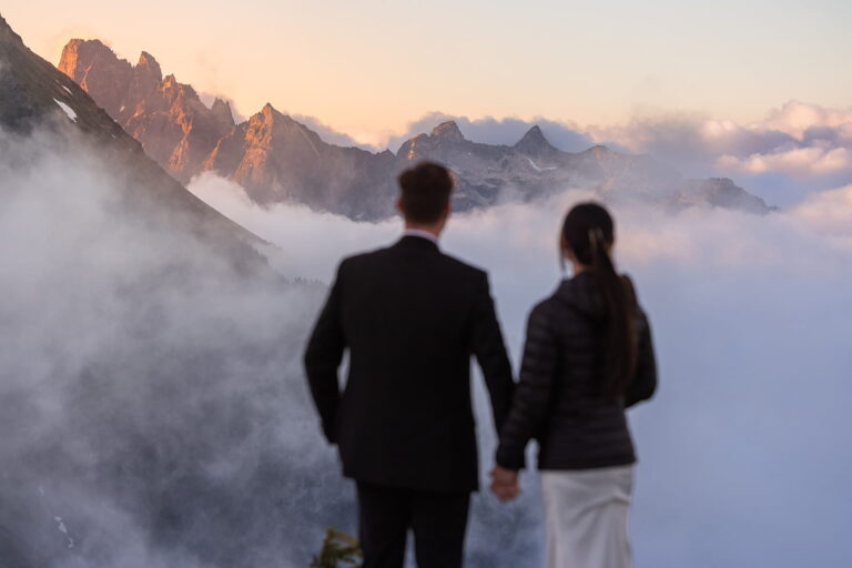 A couple holds hands looking out at the mountains during their Washington elopement with Forever and Evergreens.