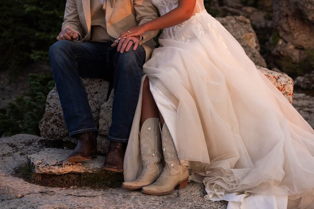 A close up of a bride and grooms cowboy boots.