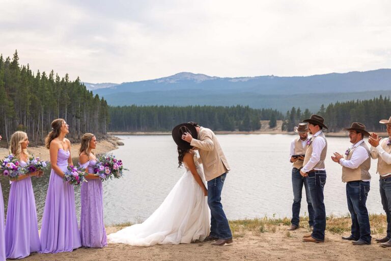 A bride and groom share their first kiss in front of Park Reservoir during their Spear-O-Wigwam wedding ceremony.