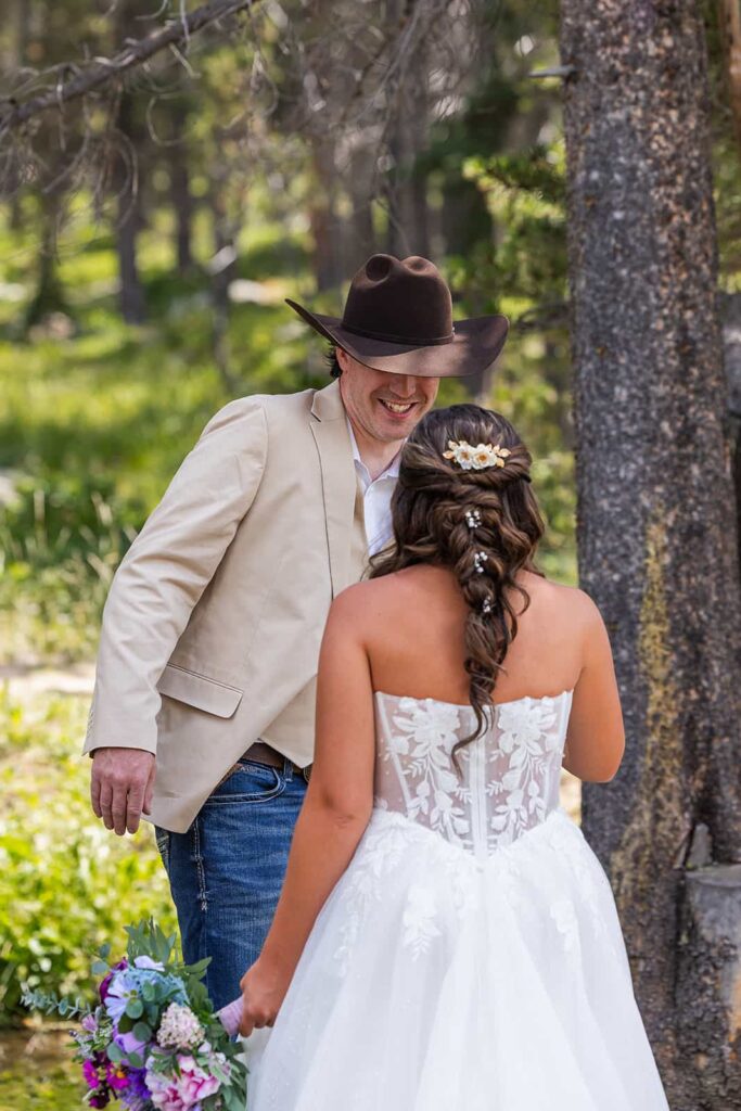 A groom turns around and smiles at his bride during their first look.