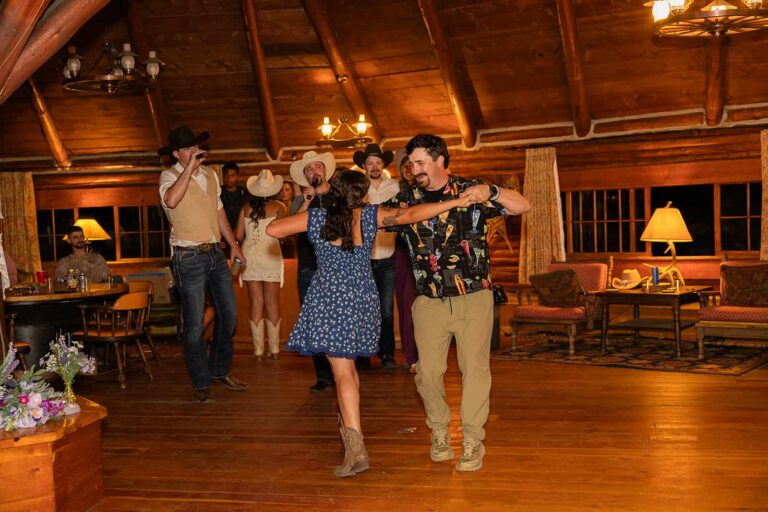 A group of people dance in the main lodge of Spear-O-Wigwam during a wedding reception.